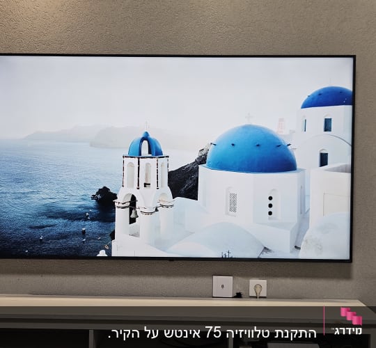 תליית טלוויזיה שטוחה על קיר בסלון מעל מזנון